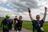 Tandem skydivers and instructors celebrating on the ground before skydiving at Parachute Ottawa