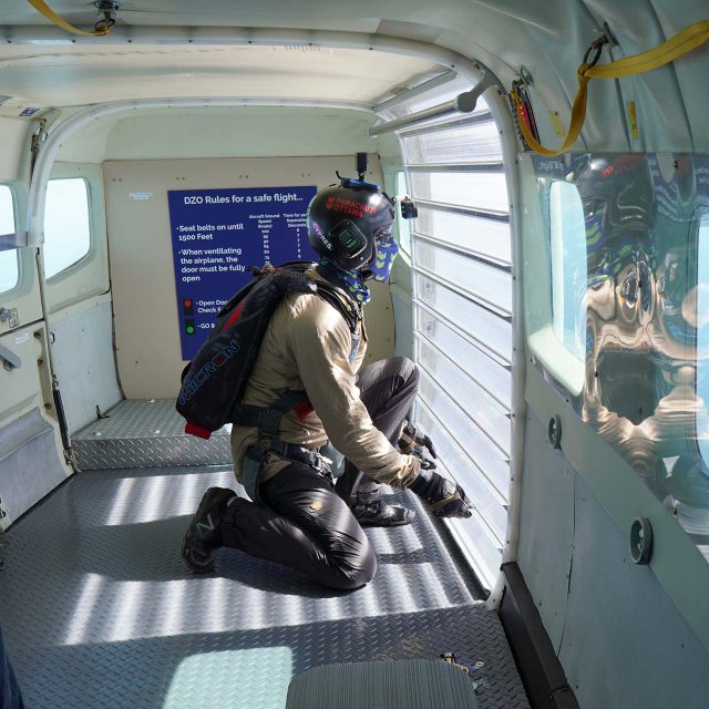 Licensed jumper preparing to open the aircraft door at altitude so he can exit